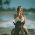 Photograph from lifestyle photography session picturing a girl on a horse on a beach in Hawaii.