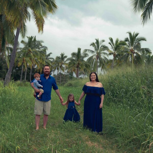 family of 4 with palm tree field background