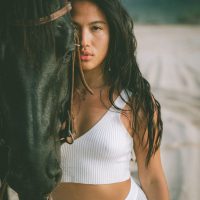 Photograph from lifestyle photography session picturing a girl on a horse on a beach in Hawaii.