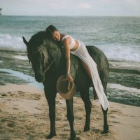 Photograph from lifestyle photography session picturing a girl on a horse on a beach in Hawaii.