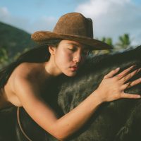 Photograph from lifestyle photography session picturing a girl on a horse on a beach in Hawaii.