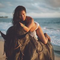 Photograph from lifestyle photography session picturing a girl on a horse on a beach in Hawaii.