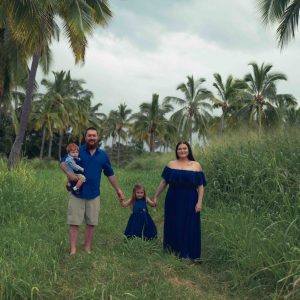 family of 4 with palm tree field background