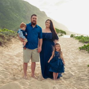 Family of 4 walking the beach on Oahu's North Shore during moody sunset session.