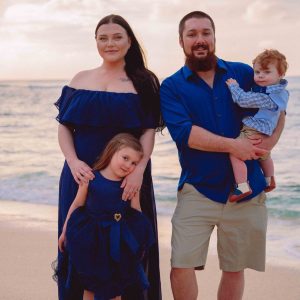 Family of 4 playing the beach on Oahu's North Shore during moody sunset session.