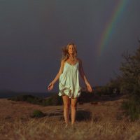 Photograph of model posing for lifestyle session. Vibrant sunset colors with rainbow