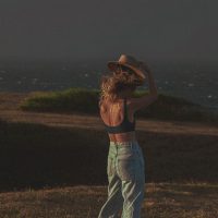 Photograph of model posing for lifestyle session. Moody overcast sunset.