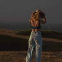 Photograph of model posing for lifestyle session. Moody overcast sunset.