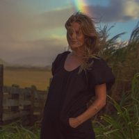 Photograph of model posing for lifestyle session. Vibrant sunset colors with rainbow