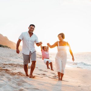 Mother, father and child playing on the beach on Oahu's North Shore during a family portrait photography session